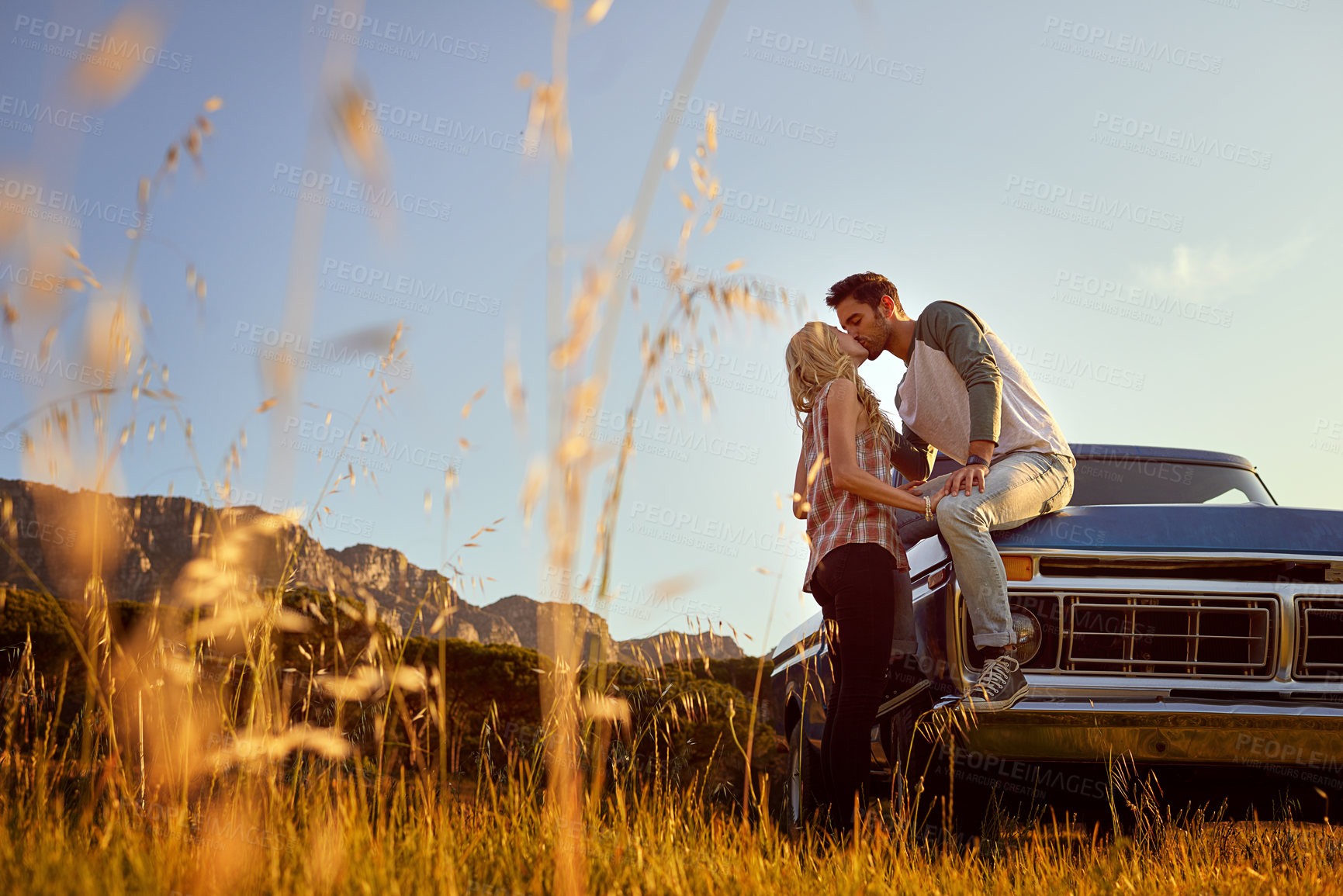 Buy stock photo Shot of an affectionate young couple enjoying a roadtrip together