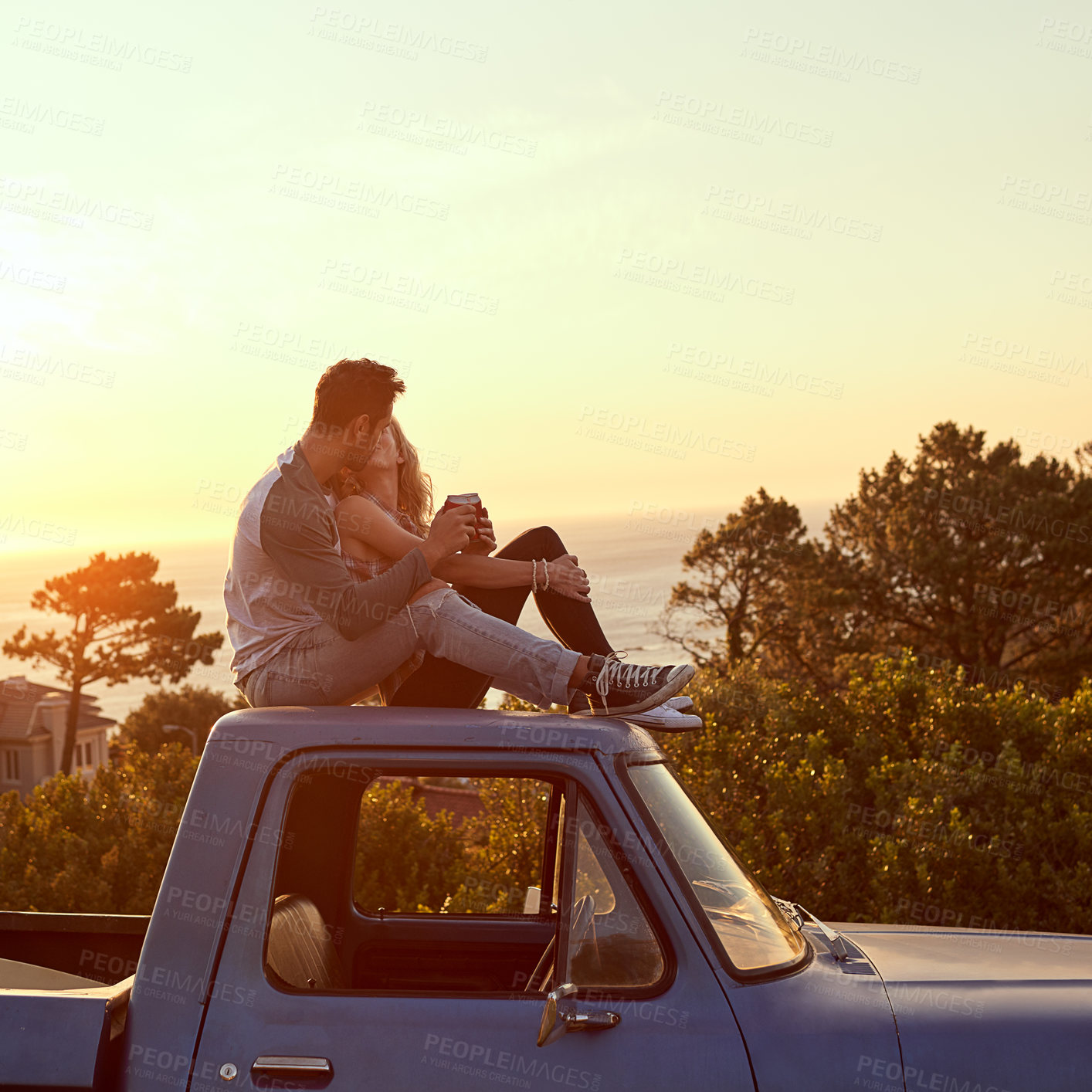 Buy stock photo Shot of an affectionate young couple enjoying a roadtrip together