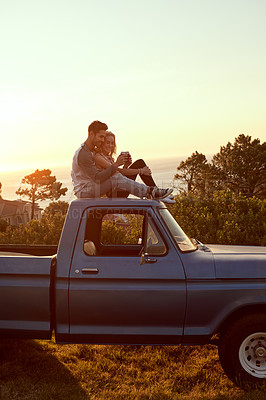 Buy stock photo Shot of an affectionate young couple having a drink while enjoying a roadtrip together