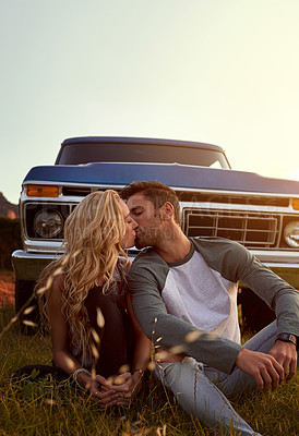 Buy stock photo Shot of an affectionate young couple enjoying a roadtrip together