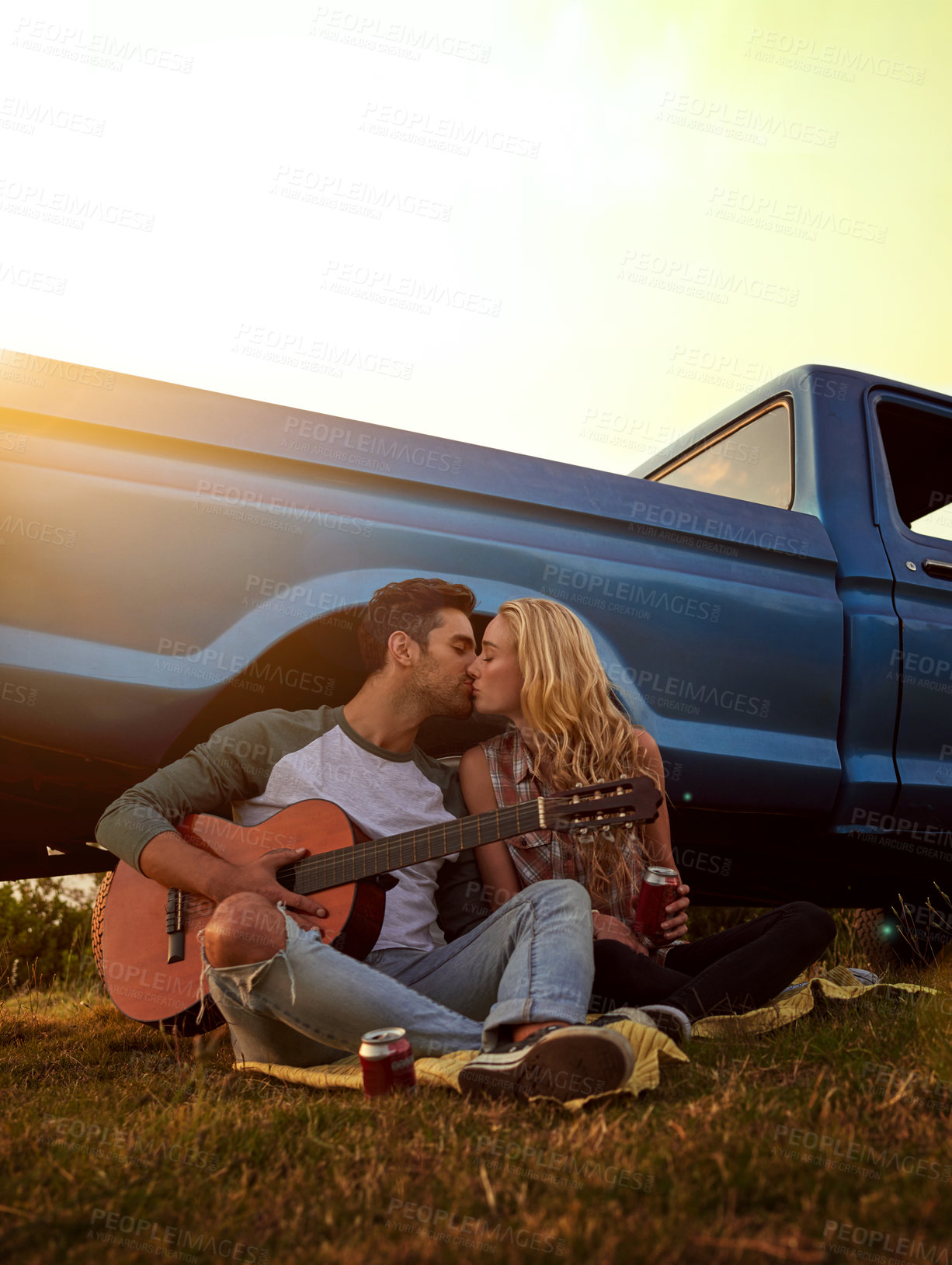 Buy stock photo Guitar, kiss and couple playing song in nature by sunset on date for romantic getaway road trip. Love, outdoor and man serenading woman with string instrument in field for vacation or holiday.