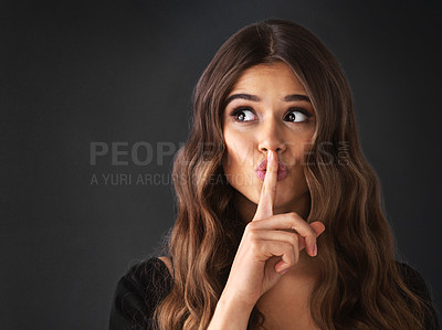 Buy stock photo Studio shot of a beautiful young woman posing with her finger on her lips