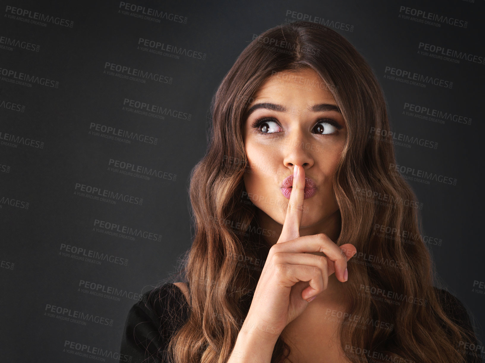 Buy stock photo Studio shot of a beautiful young woman posing with her finger on her lips