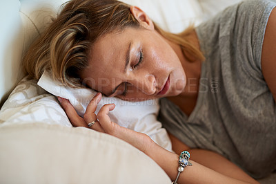 Buy stock photo Close up shot of an attractive woman sleeping on her side in bed at home