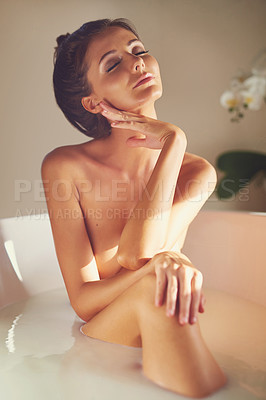 Buy stock photo Shot of a beautiful nude woman relaxing in a bathtub filled with milk at home