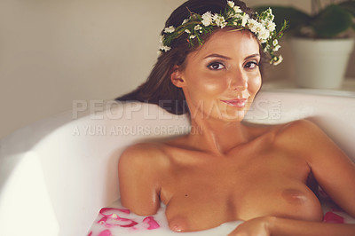 Buy stock photo Portrait of a beautiful nude woman relaxing in a bathtub filled with milk and flower petals at home