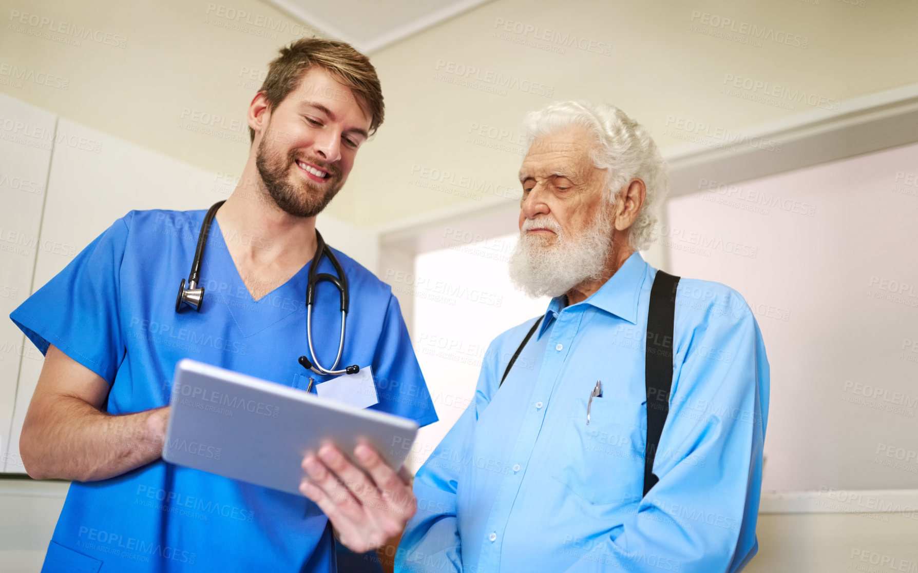 Buy stock photo Shot of a young doctor explaining a diagnosis to his senior patient by using a tablet