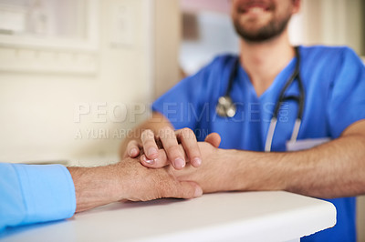 Buy stock photo Shot of an unidentifiable young doctor holding his senior patient's hand in support
