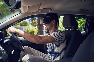 Buy stock photo Shot of a happy young man driving a car while wearing a virtual reality headset