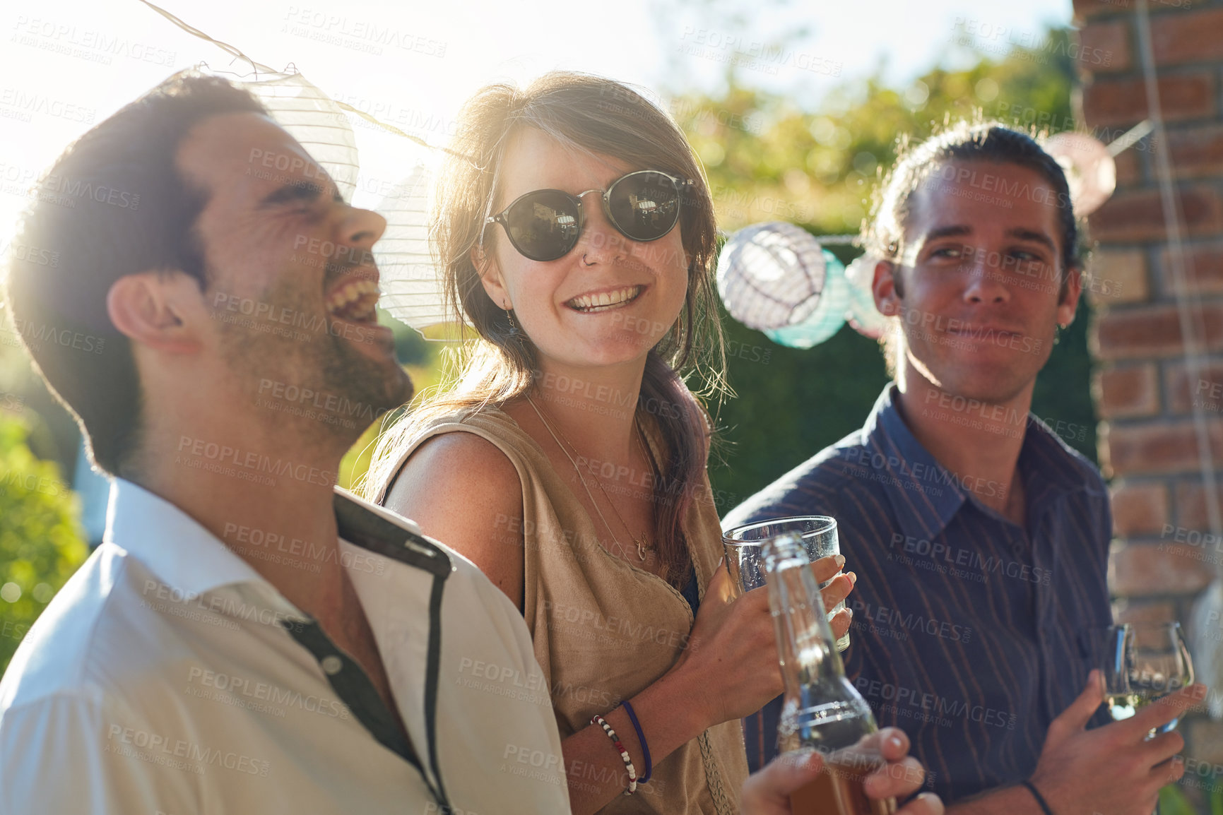 Buy stock photo Shot of a group of happy young friends hanging out at a backyard dinner party