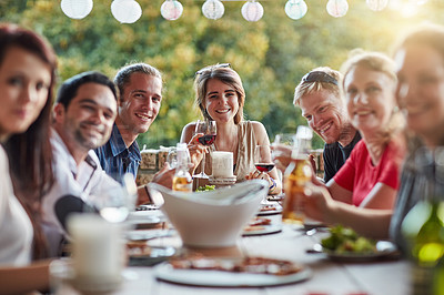 Buy stock photo Portrait of a group of happy young friends sharing a meal at a backyard dinner party