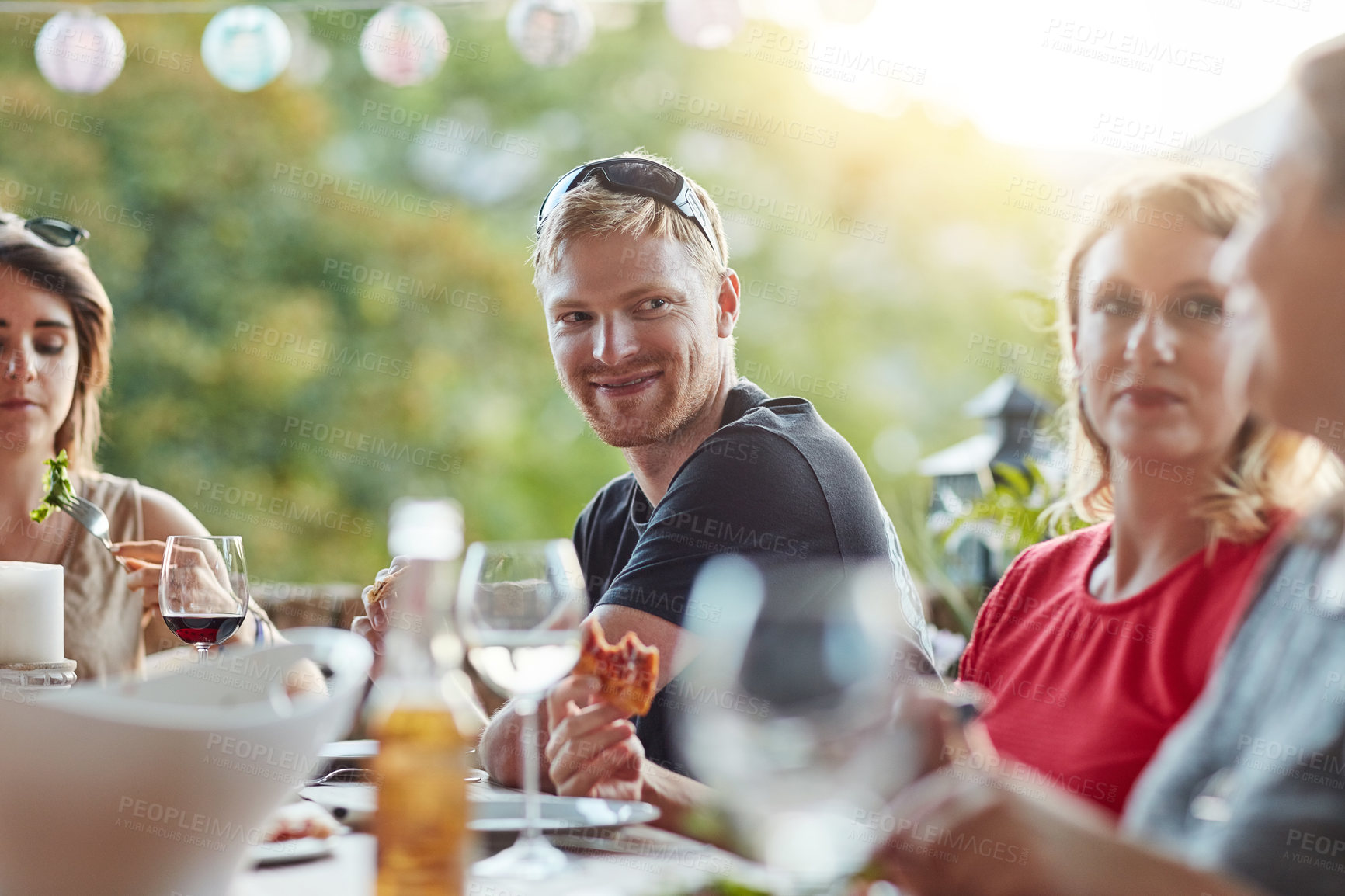 Buy stock photo Shot of a group of happy young friends hanging out at a backyard dinner party