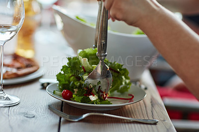 Buy stock photo Shot of an unidentifiable young man serving salad at a dinner party with friends