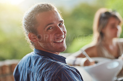 Buy stock photo Portrait of a happy young man sharing a meal with friends at an outdoor dinner party