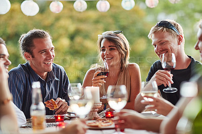 Buy stock photo Shot of a group of happy young friends sharing a meal at a backyard dinner party