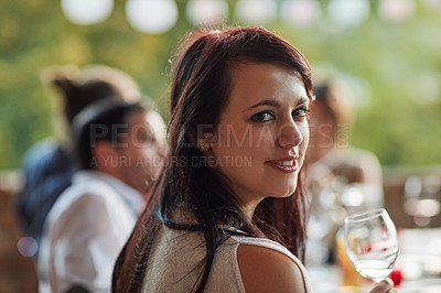 Buy stock photo Portrait of a happy young woman sharing a meal with friends at an outdoor dinner party