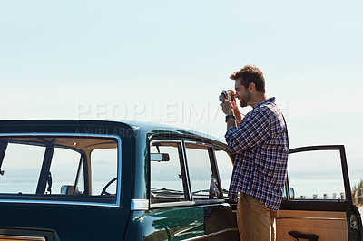 Buy stock photo Cropped shot of a handsome man taking photos while enjoying a roadtrip