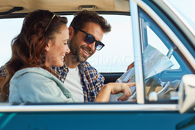 Buy stock photo Cropped shot of an affectionate couple checking a map while enjoying a roadtrip