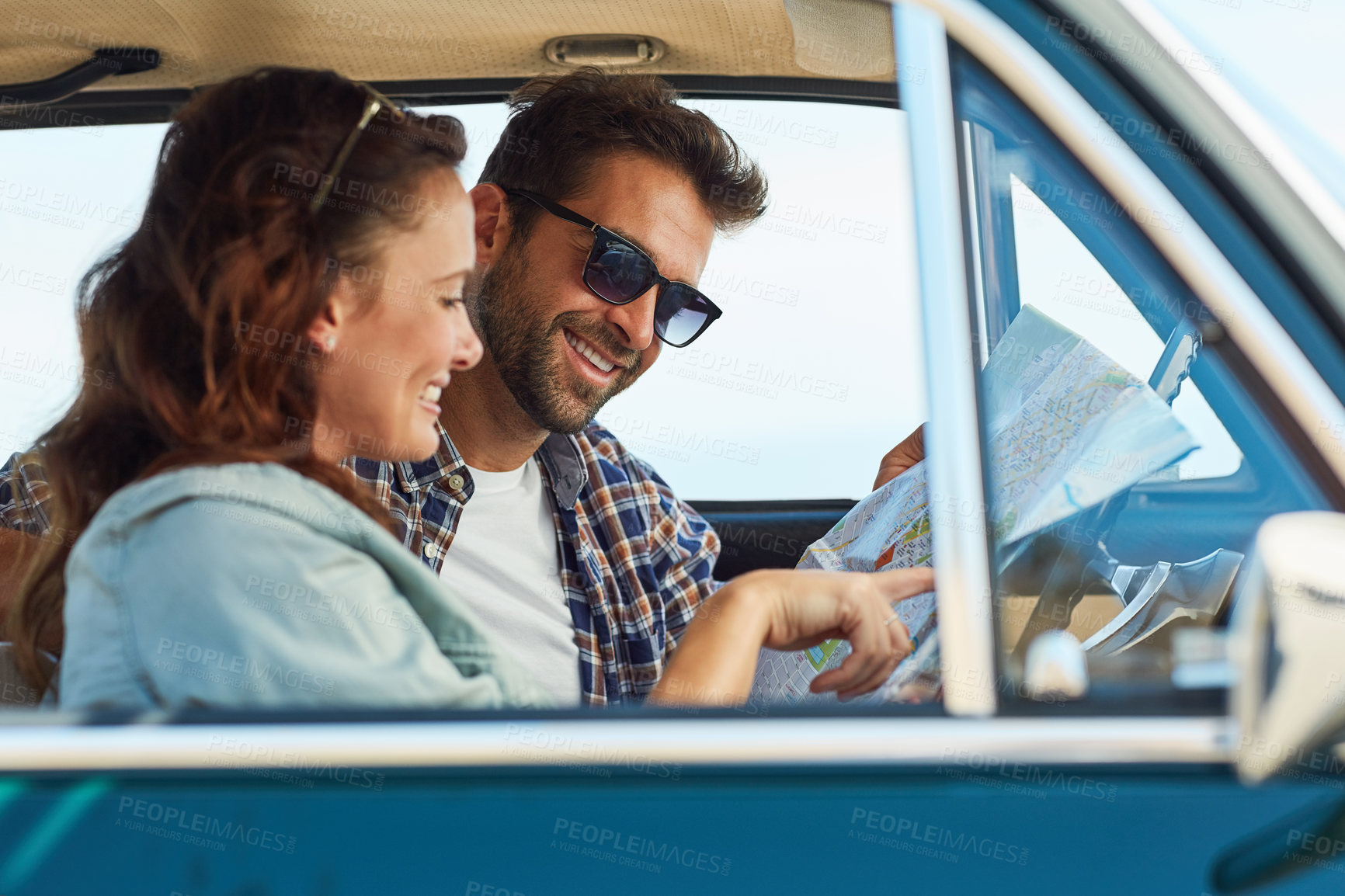 Buy stock photo Cropped shot of an affectionate couple checking a map while enjoying a roadtrip