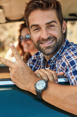 Buy stock photo Cropped portrait of a handsome man giving you a peace sign while enjoying a roadtrip