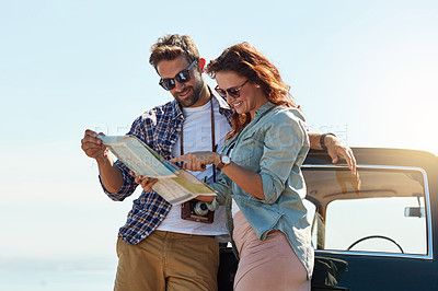Buy stock photo Cropped shot of an affectionate couple looking at a map while enjoying a roadtrip