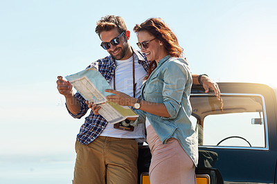 Buy stock photo Cropped shot of an affectionate couple looking at a map while enjoying a roadtrip