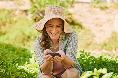 Buy stock photo Shot of a happy young farmer holding a pile of soil with a seedling growing out of it outside