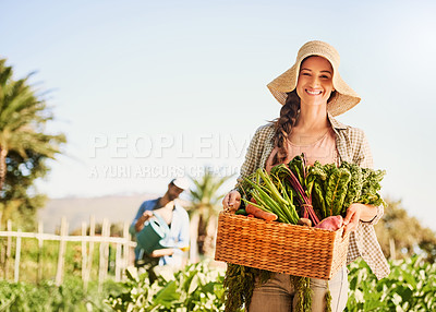 Buy stock photo Portrait of a happy young farmer harvesting herbs and vegetables in a basket on her farm
