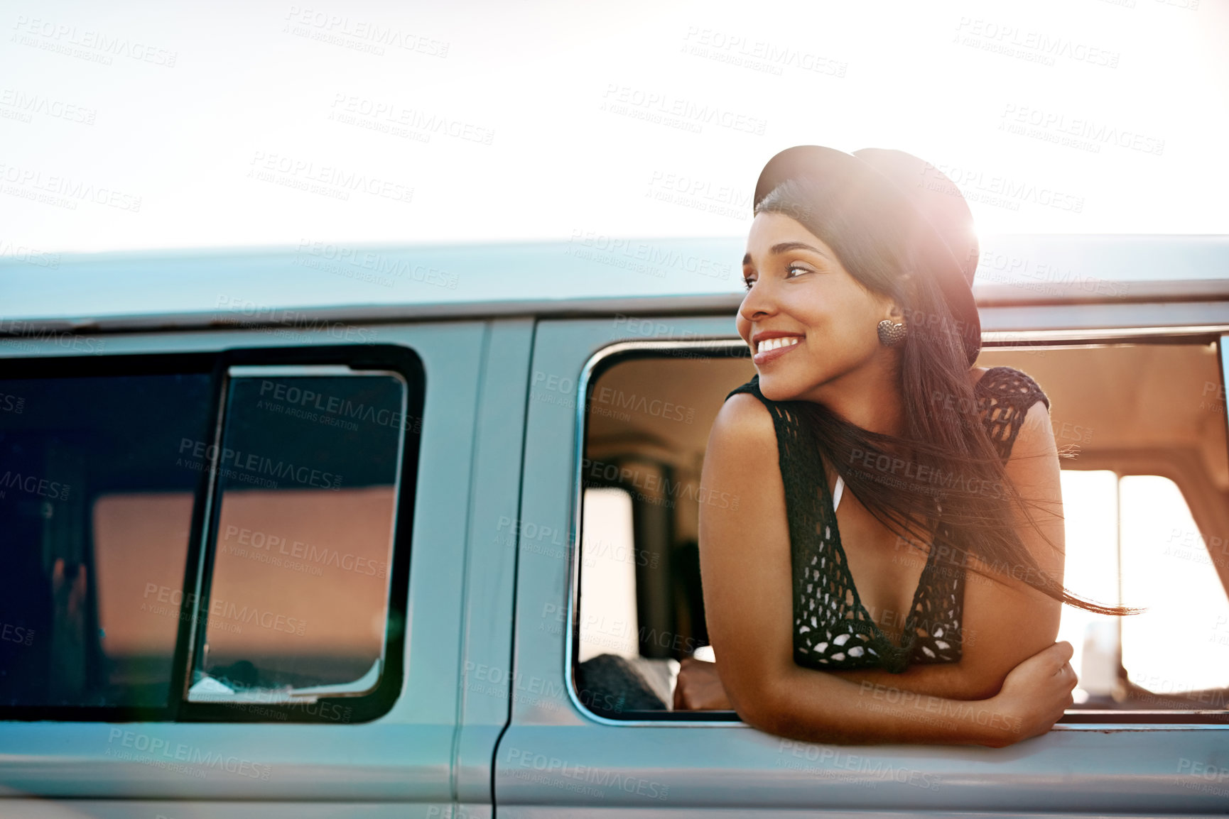 Buy stock photo Shot of a happy young woman leaning out of the window during a road trip