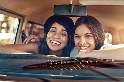 Buy stock photo Shot of two happy young friends going on a road trip