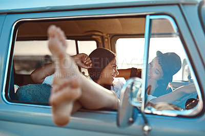 Buy stock photo Shot of a young woman’s legs hanging out of the window on a road trip with her friend