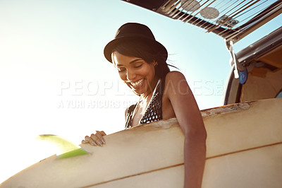 Buy stock photo Shot of a young woman getting ready for a surf on a road trip