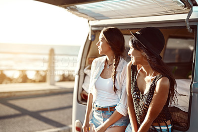 Buy stock photo Shot of two happy young friends enjoying a relaxing road trip