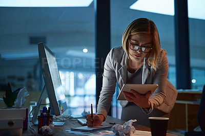 Buy stock photo Cropped shot of a businesswoman working on a digital tablet in her office late into the night