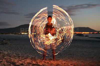 Buy stock photo Portrait of a happy young man playing with a sparkler on the beach at sunset