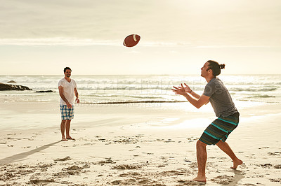 Buy stock photo Shot of two happy young friends playing with a ball on the beach