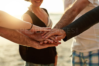 Buy stock photo Cropped shot of a group of unidentifiable friends putting their hands in a pile on the beach