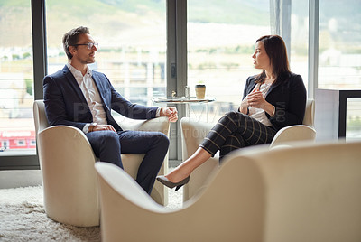 Buy stock photo Shot of two business people having a discussion in a modern office