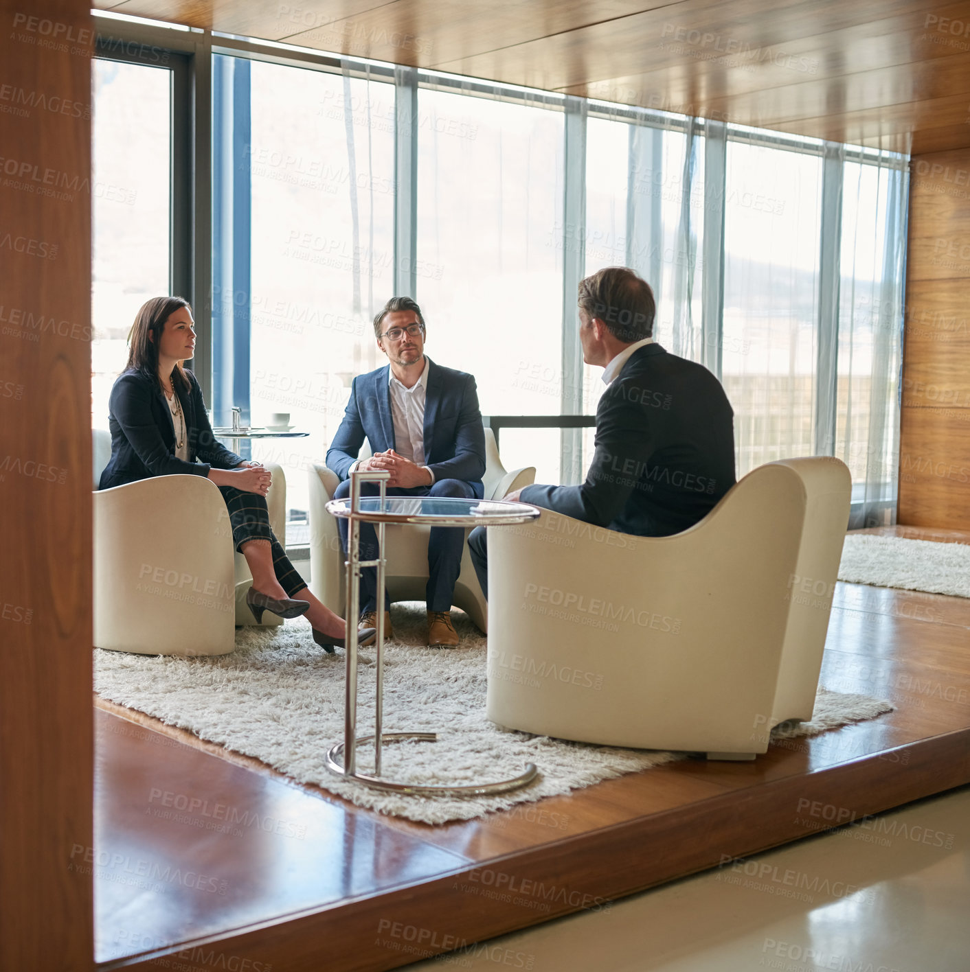 Buy stock photo Shot of a group of business people having a discussion in a modern office