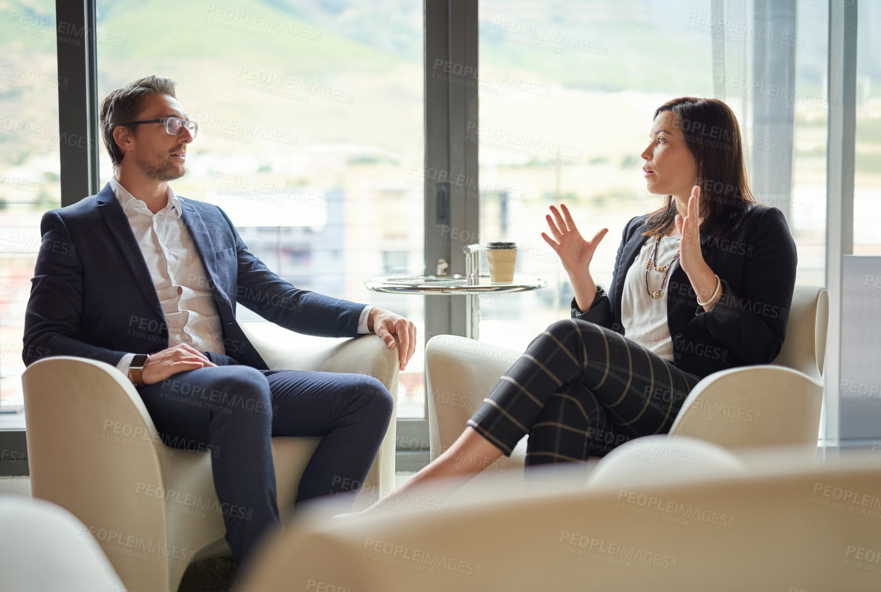 Buy stock photo Shot of a group of business people having a discussion in a modern office