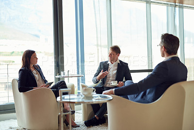 Buy stock photo Shot of a group of business people having a discussion in a modern office