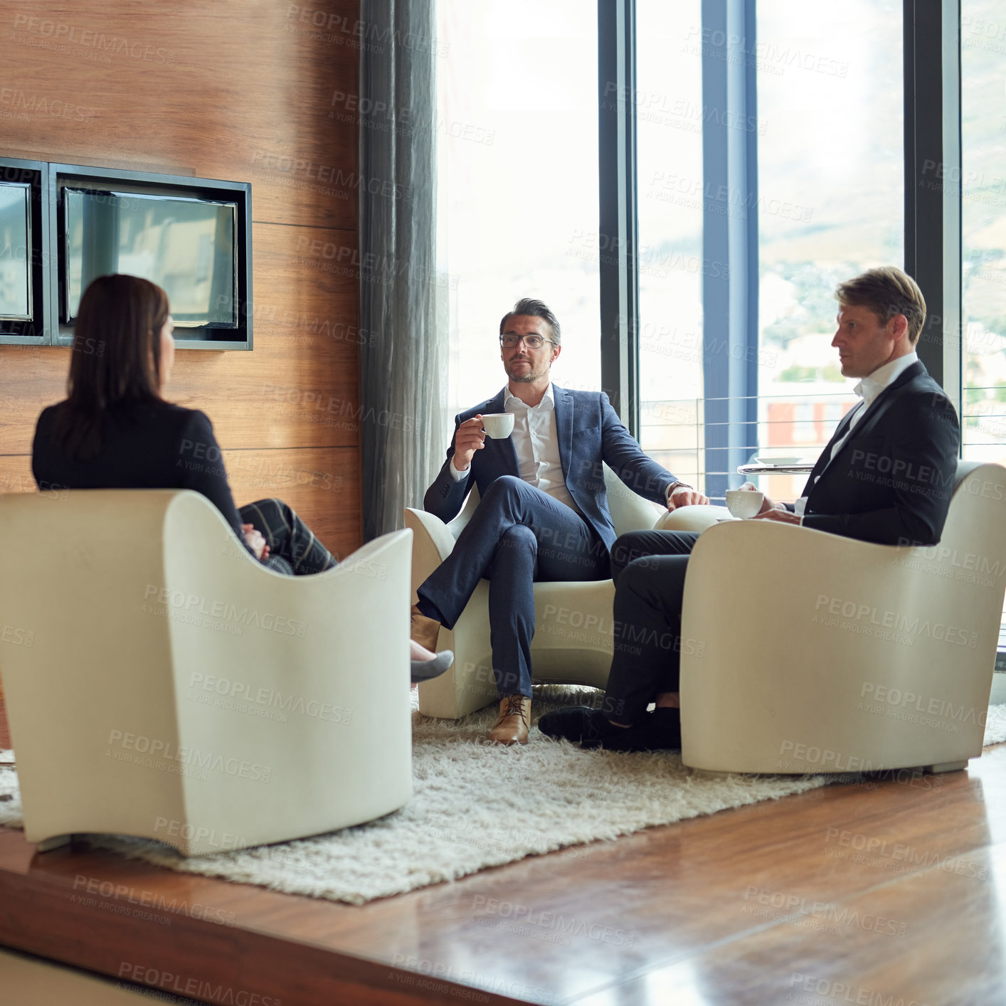 Buy stock photo Shot of a group of business people having a discussion in a modern office