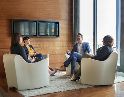 Buy stock photo Shot of a group of business people having a discussion in a modern office