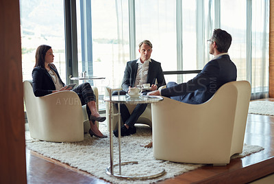 Buy stock photo Shot of a group of business people having a discussion in a modern office