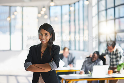 Buy stock photo Portrait of an ambitious young designer posing with her team in the background in the office