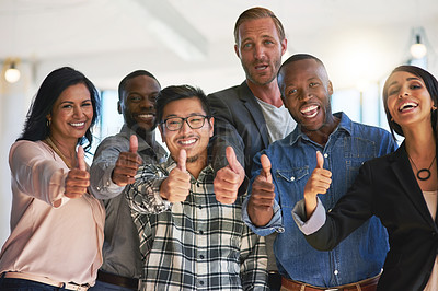 Buy stock photo Portrait of a group of happy creative colleagues showing a thumbs up together in the office