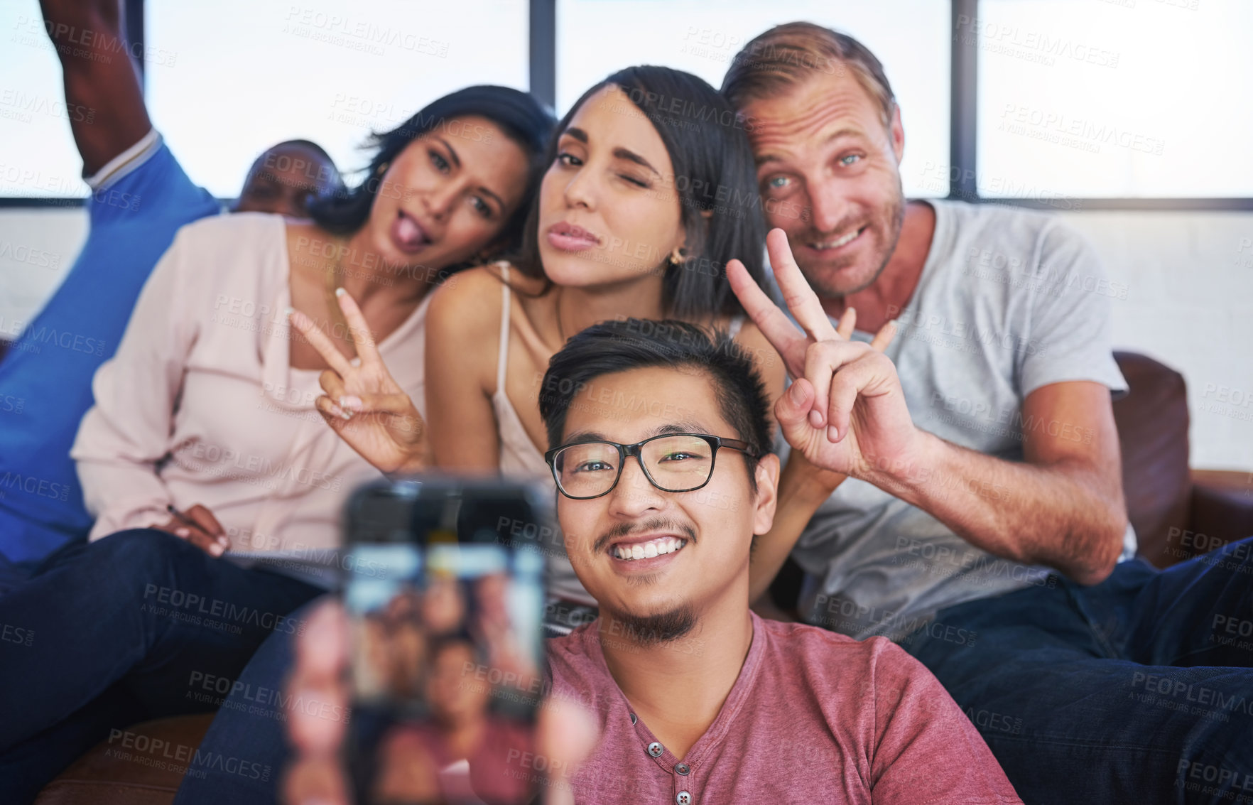 Buy stock photo Business people, happy and selfie in office with peace, diversity and sofa for playful, joy and fun. Creative agency, smile and team in workplace with memory for collaboration, cooperation or startup