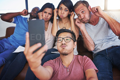 Buy stock photo Shot of a happy group of creative colleagues posing for a selfie together in the office