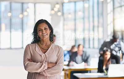 Buy stock photo Portrait of an ambitious young designer posing with her team in the background in the office