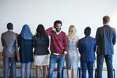 Buy stock photo Portrait of a happy job applicant standing in line with a group of unidentifiable businesspeople